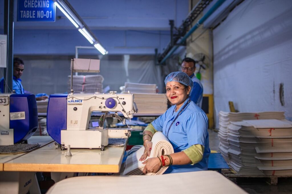 garment factory worker operating an industrial sewing machine